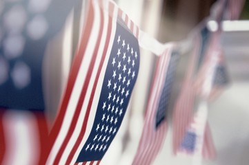 Row of small identical American flags, decorative for themes of summer, pride, Americana, USA flag concept, god bless America.