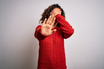 Canvas Print - Middle age brunette woman wearing casual sweater standing over isolated white background covering eyes with hands and doing stop gesture with sad and fear expression. Embarrassed and negative concept.