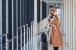 © standret - Young female passenger in warm clothes walking with her dog in airport hall