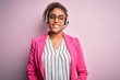 Young african american call center agent girl wearing glasses working using headset with a happy and cool smile on face. Lucky person.