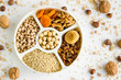 © Gulsen - Ingredients of ashura dessert ;walnut,hazelnuts,wheat,apricot,fig,grape and chickpea in the divided plate.Top view.