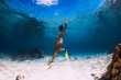 © artifirsov - Woman freediver swimming over with yellow fins in ocean. Freediving or snorkeling in Mauritius