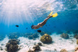 © artifirsov - Woman freediver swimming over with yellow fins in ocean. Freediving or snorkeling in Mauritius