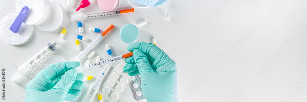 Worldwide coronavirus epidemic concept. Pandemic COVID-19, 2019-nCoV. Testing of coronavirus vaccine. Syringe with covid-19 vaccine, against the background of drugs, pills and medical supplies - obrazy, fototapety, plakaty 
