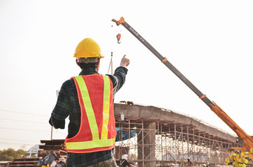 Construction engineer pointing the hand with the background of the construction site