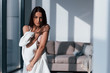 © standret - Young beautiful brunette standing indoors and covering her body by white towel