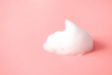 White Foam Snear From Soap, Shampoo Or Cleanser On Pink Background With Selective Focus. Close-up, Macro