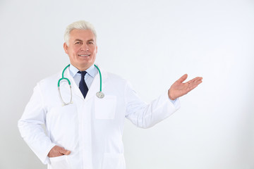 Wall Mural - Portrait of senior doctor with stethoscope on white background