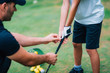 © Microgen - Golf Instructor adjusting young boy’s grip