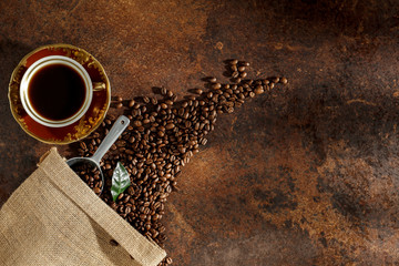 Wall Mural - Old retro cup of warm black coffee  seen from above. Coffee with dark brown grunge background. Copy space. Space for advertising products.