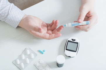 person measures blood sugar with glucometer