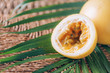 © jchizhe - Yellow maracuya with palm leaves on rattan background. Copy space. Passion fruit. Creative design banner. Summer time. Tropical travel, exotic fruit. Vegan and vegetarian concept