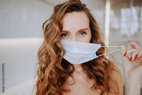 Close up portrait of beautiful young european woman wearing protective mask for corona virus prevention, hygiene to stop spreading coronavirus. Avoid contaminating Corona virus Covid-19 concept