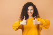 © denis_vermenko - Young happy cheerful curly woman showing thumb up isolated over beige background.
