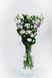 Beautiful bouquet of spring flowers in vase. Floral composition of fresh white violet eustoma flowers. Gift. Celebration concept. Blooming flowers.  