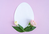 Fototapeta Tulipany - Easter creative composition.  Flat lay with shape of easter egg, frame  of flowers on pink  background. Minimal spring concept. Copy space