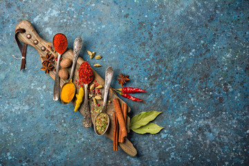 Wall Mural - Different spices, dry kitchen herbs and seeds in vintage spoons for tasty meals