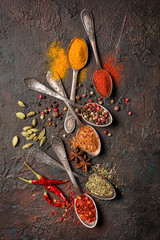 Wall Mural - Different spices, dry kitchen herbs and seeds in vintage spoons for tasty meals