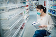© eldarnurkovic - Shopping during the epidemic.Buyer wearing a protective mask.Shopping for enough food and cleaning products.Pandemic quarantine preparation.Pandemic quarantine preparation.Sold out household supplies