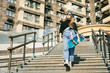 © Elizaveta - Urban woman with skate. Hipster girl with skateboard in city. Extreme sport and emotions concept. Alternative lifestyle. Stylish hipster girl holding skateboard and posing. Street style outfit