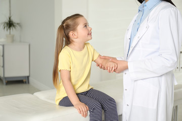 Canvas Print - Professional orthopedist examining little patient's arm in clinic