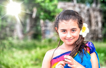 Sticker - Travel and holiday concept. Young girl wearing tropical flower on the beach with forest background