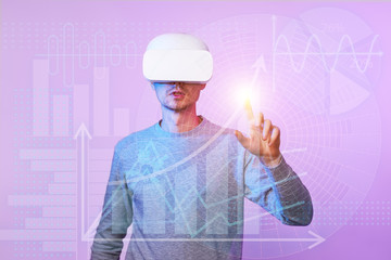 Man uses a virtual reality headset to work with data in the form of graphs and charts.