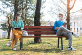 Fototapeta  - Woman and man in social distancing sitting on bench