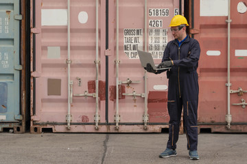 Wall Mural - caucasian container yard and cargo inspector at work checking container loading at containers yard loading area