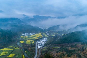 Wall Mural -  Rapeseed flower in spring in the ancient village in cloud and fog, Hongguan Village, Wuyuan, Jiangxi 