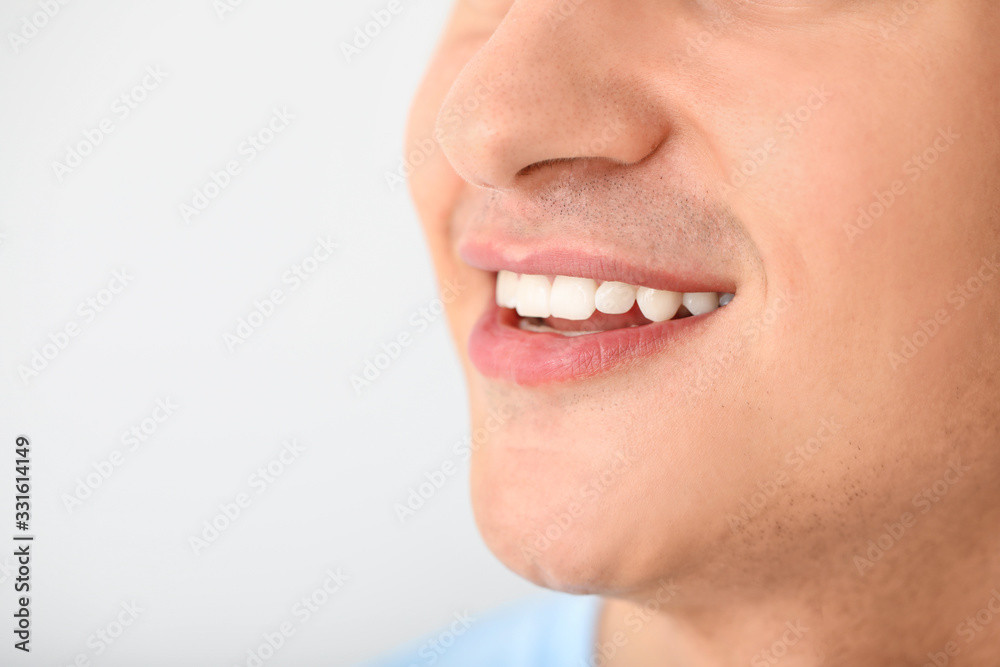Handsome smiling man on light background, closeup