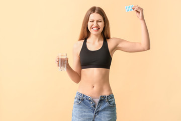 Sticker - Woman in loose jeans and with weight loss pills on color background