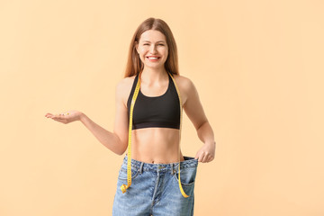 Sticker - Woman in loose jeans and with weight loss pills on color background