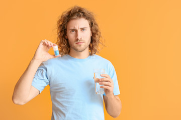 Sticker - Young man with oral erectile dysfunction medication on color background