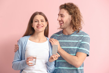 Sticker - Young couple with birth control pills on color background