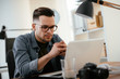 © JustLife - Designer in office. Businessman working on new architect project.