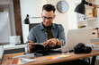 © JustLife - Designer in office. Businessman working on new architect project.
