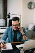 © JustLife - Businessman in office. Handsome man talking on phone at work.