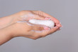 © Svitlana - Washing female hands with soap on a gray background
