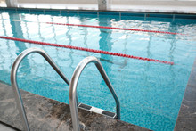 Close-up Of Metal Pool Stair With Railing Used For Entry Into Swimming Pool In Health Club