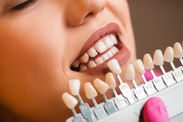 Beautiful blonde patient at the dentist. The young women's teeth being checked, examined and treated by a female dentist with the help of special medical tools