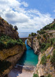 Vertical photo. Bay of Fiordo di furore beach. Incredible beauty panorama of a mountains paradise. The rocky seashore of southern Italy. Sunny day. Stone bridge and clear water. Amalfi coast.
