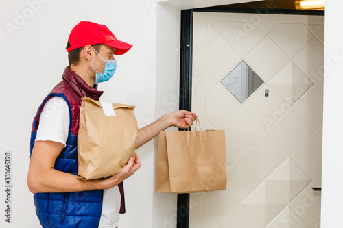 Fotografía Delivery man holding paper bag with food on white background, food delivery man