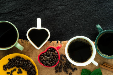 Poster - still life photography of colorful many coffee cups set above brown hemp sack sheet on the old black stone