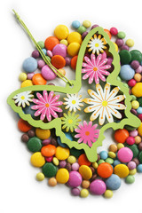 Wall Mural - Colorful chocolate candies also called smarties in shape of a Easter egg with decoration isolated on white background. Easter background