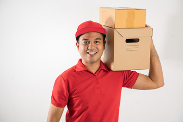 Wall Mural - Red Delivery handsome asian man holding parcel cardboard box on isolated white background.