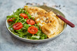 Classic egg omelette served with cherry tomato and arugula salad on side