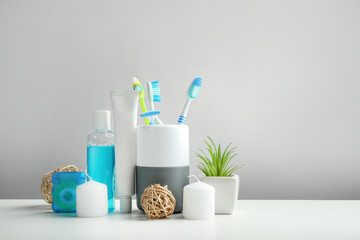 Wall Mural - Toothbrushes in cup and other dental products on grey background