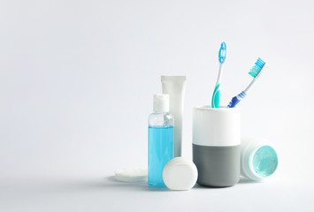 Wall Mural - Plastic toothbrushes in cup and other dental products on white background