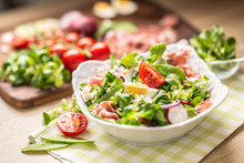 Fresh Spring Salad With Green Leaves Tomatoes Egg Radish Red Onion Young Peas Prosciutto Feta Cheese And Olive Oil